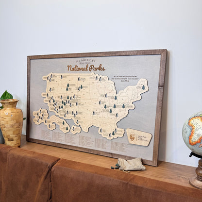 National Parks Travel Map on a ledge leaning against a wall with decorative items around it. 