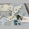Close up of the national parks travel map and the green tree markers that come with it to track your travels. 