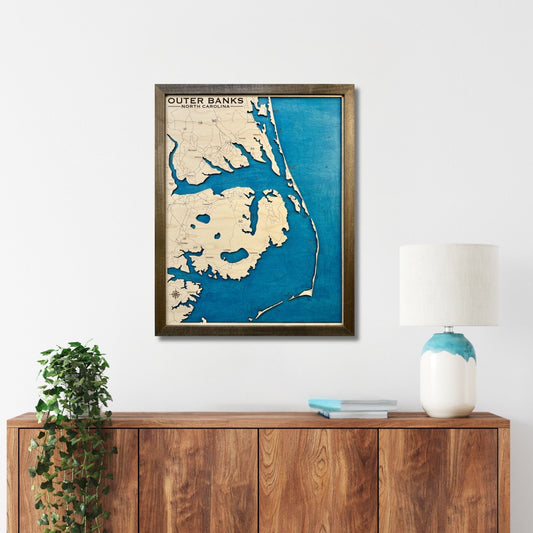 Outer Banks coastline map hanging on a wall above a cabinet. 