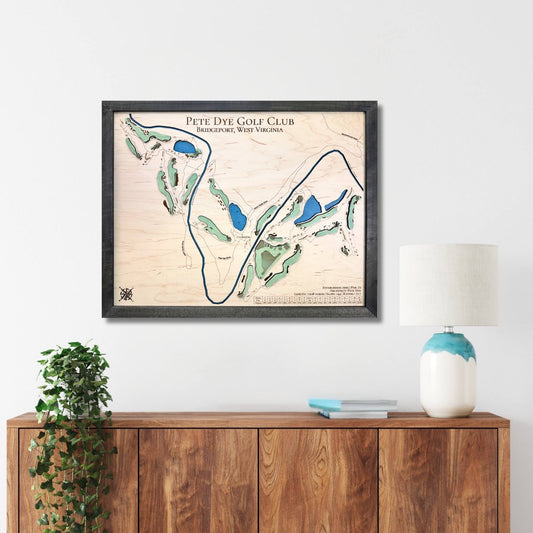Framed golf course map on a wall above a wooden console table.