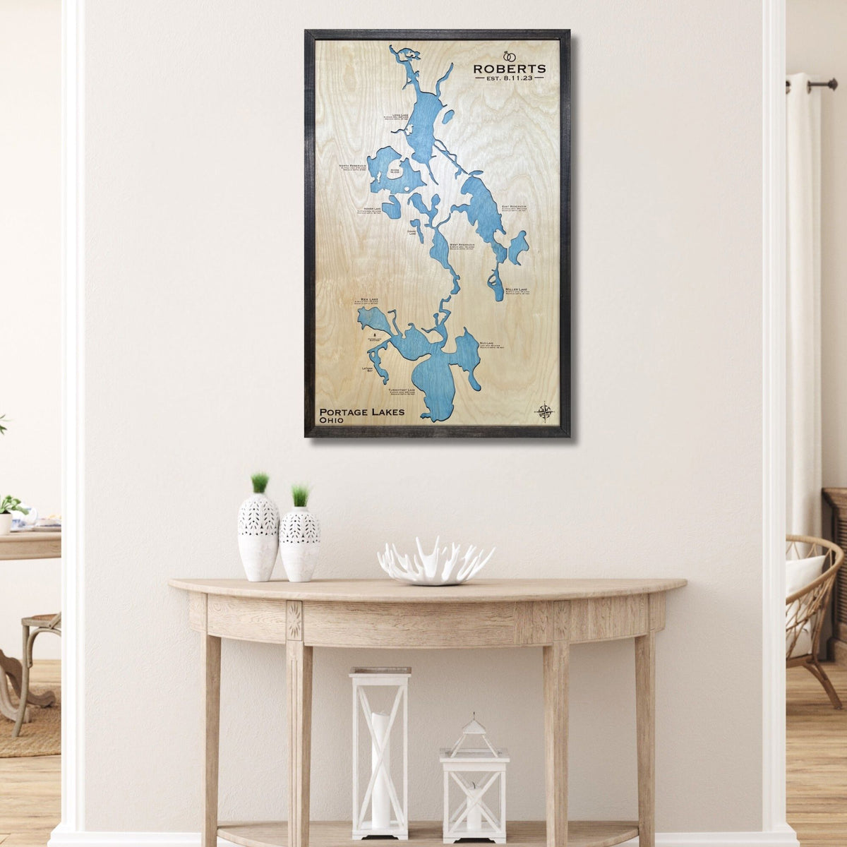 Framed custom map of Portage Lakes on a wall above a wooden table.