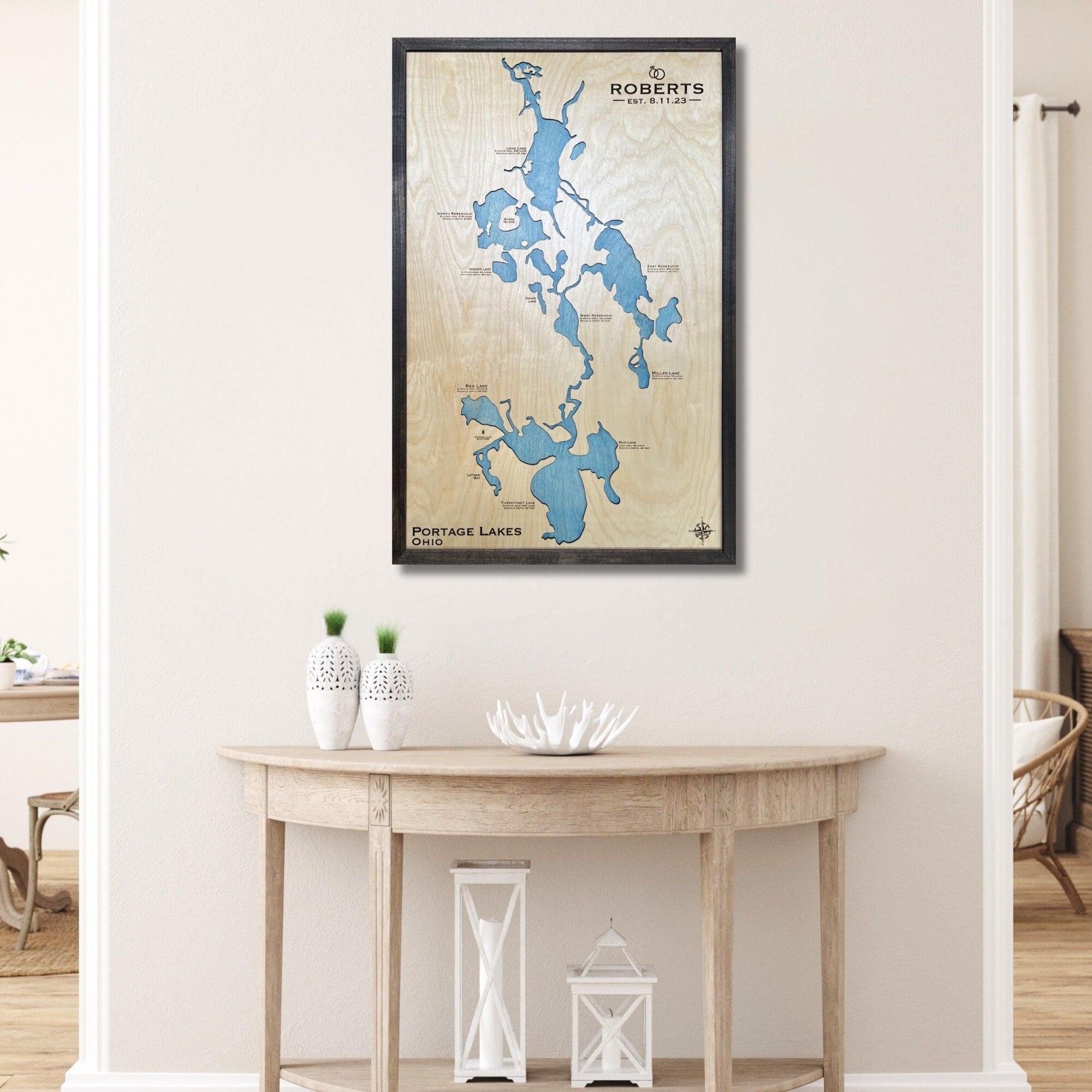 Framed custom map of Portage Lakes on a wall above a wooden table.