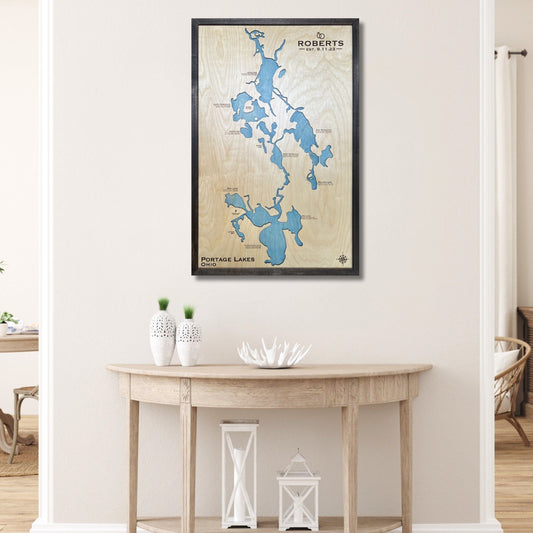 Framed custom map of Portage Lakes on a wall above a wooden table.