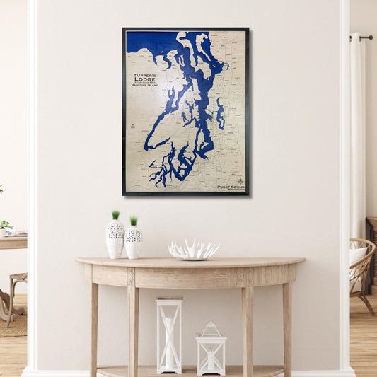 Custom wooden map of Puget Sound hanging on a wall above a table. 