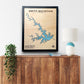 Framed single water layer map of Smith Mountain Lake on a wooden surface with a lamp and plant.