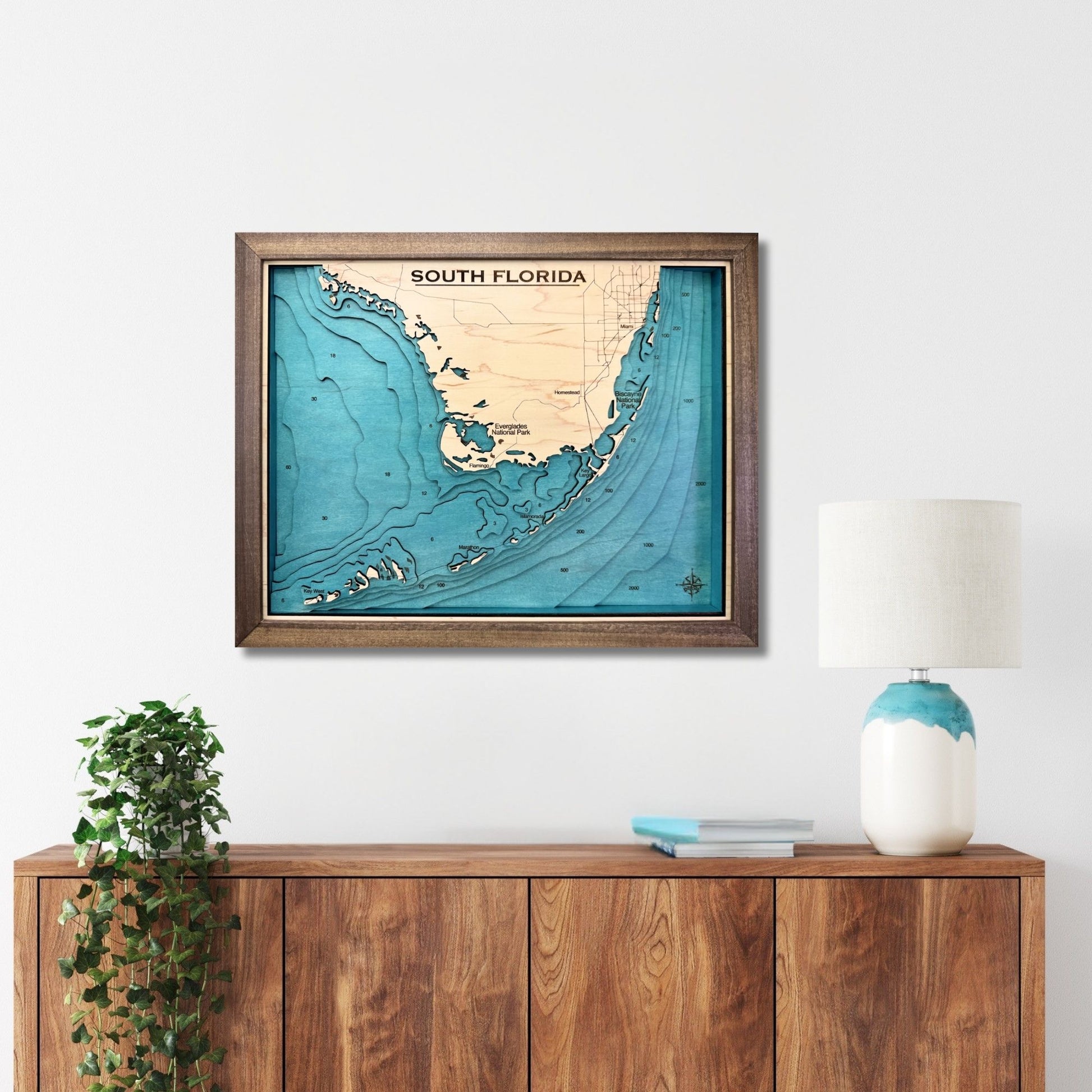 Framed South Florida and Florida Keys map hanging on a wall above a console. 