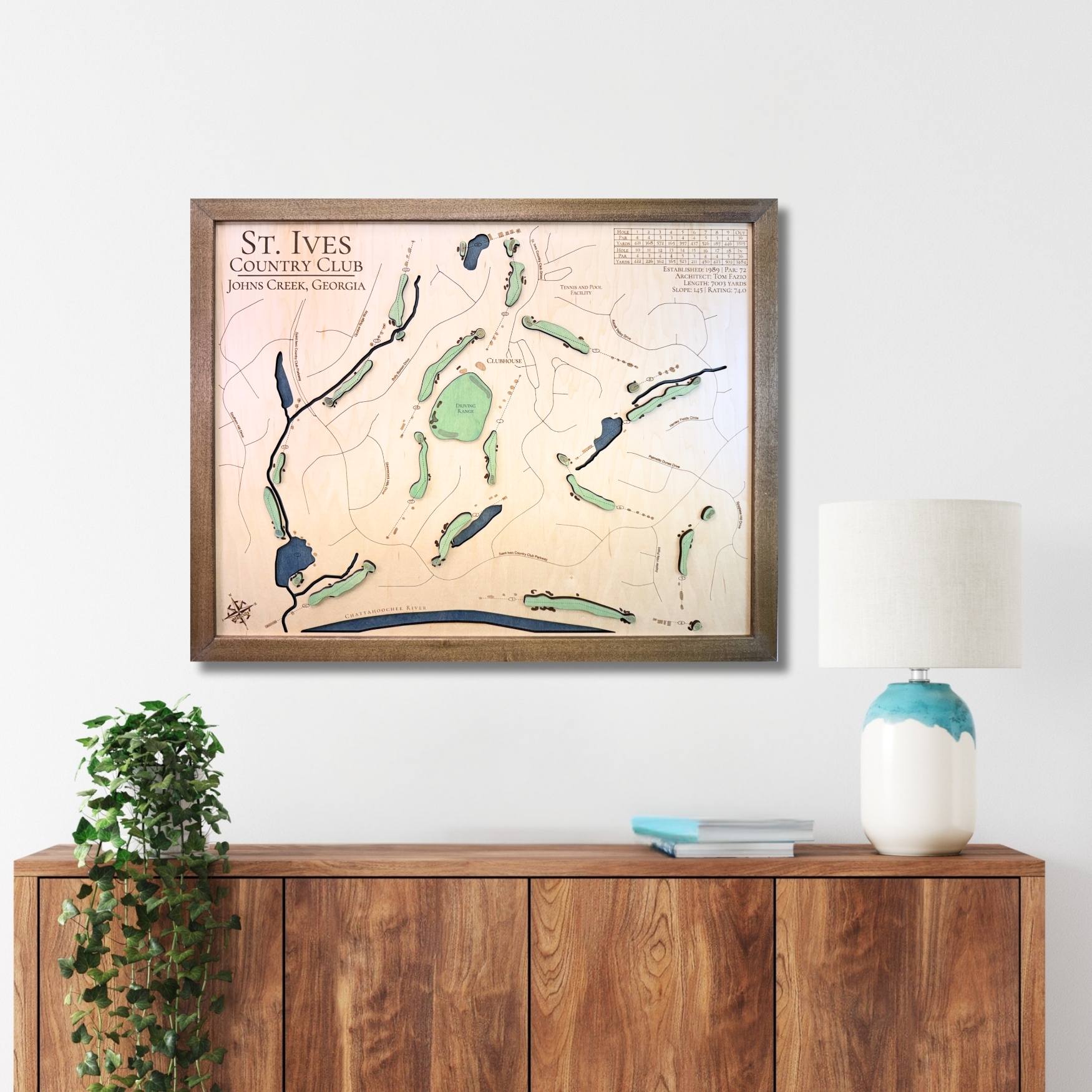 Framed wooden golf map of St. Ives Country Club on a wall above a wooden console table.