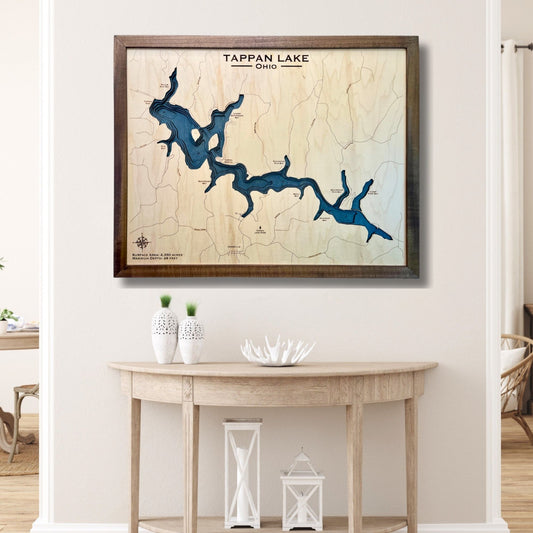 Framed multilayer wooden map of Tappan Lake, Ohio on a wall above a wooden table.