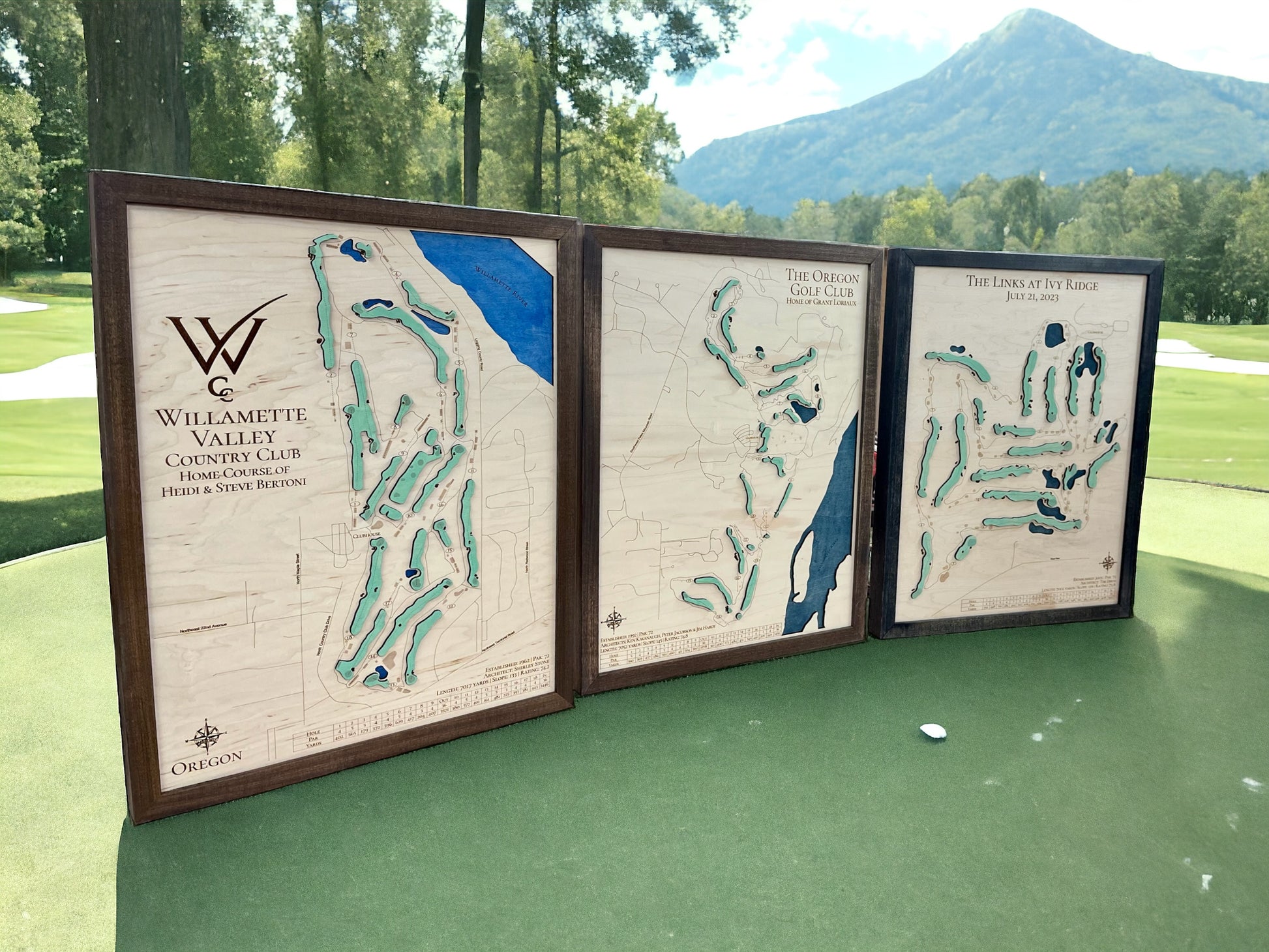 Three large wooden golf course maps standing on a golf green.