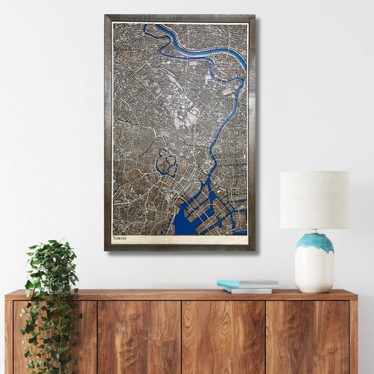 Framed city map of Tokyo on a wall above a wooden cabinet with decorative items.