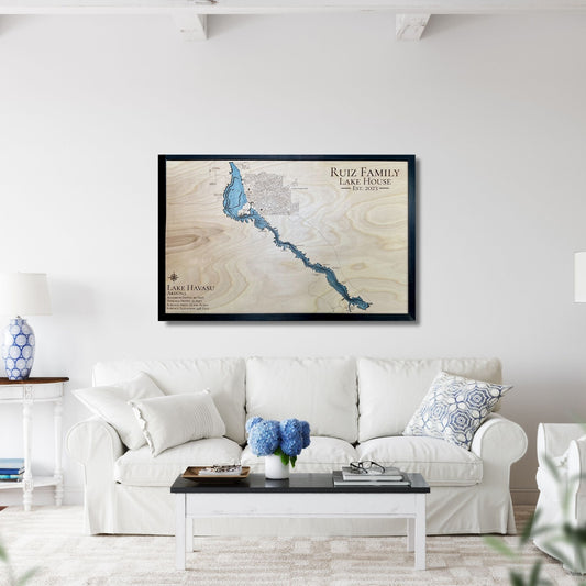 Framed wooden map of a lLake Havasu on a wall above a white sofa in a living room.