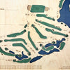 Close up of wooden golf course map with green fairways, blue water hazards, and engraved text. 