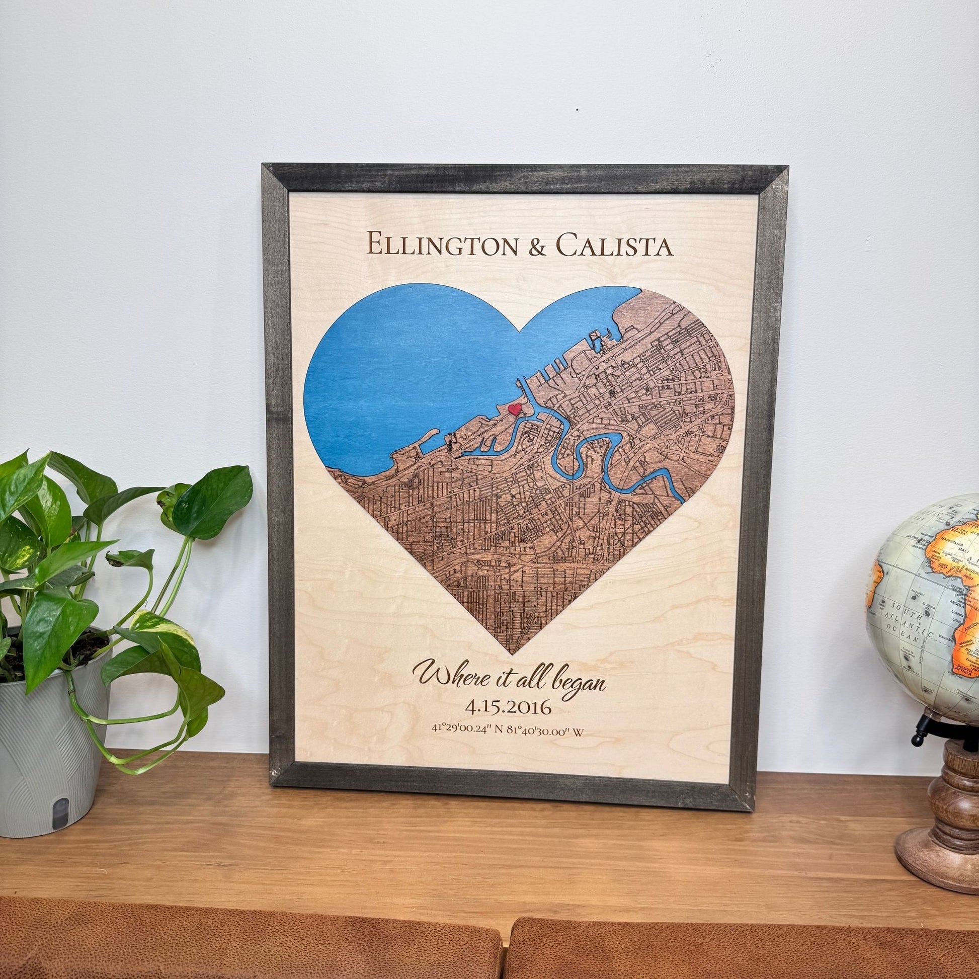Wedding gift heart map sitting on a wood table with decorative objects. 