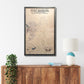Framed custom wooden military map of Fort Benning on a wall above a wooden sideboard with decor items.