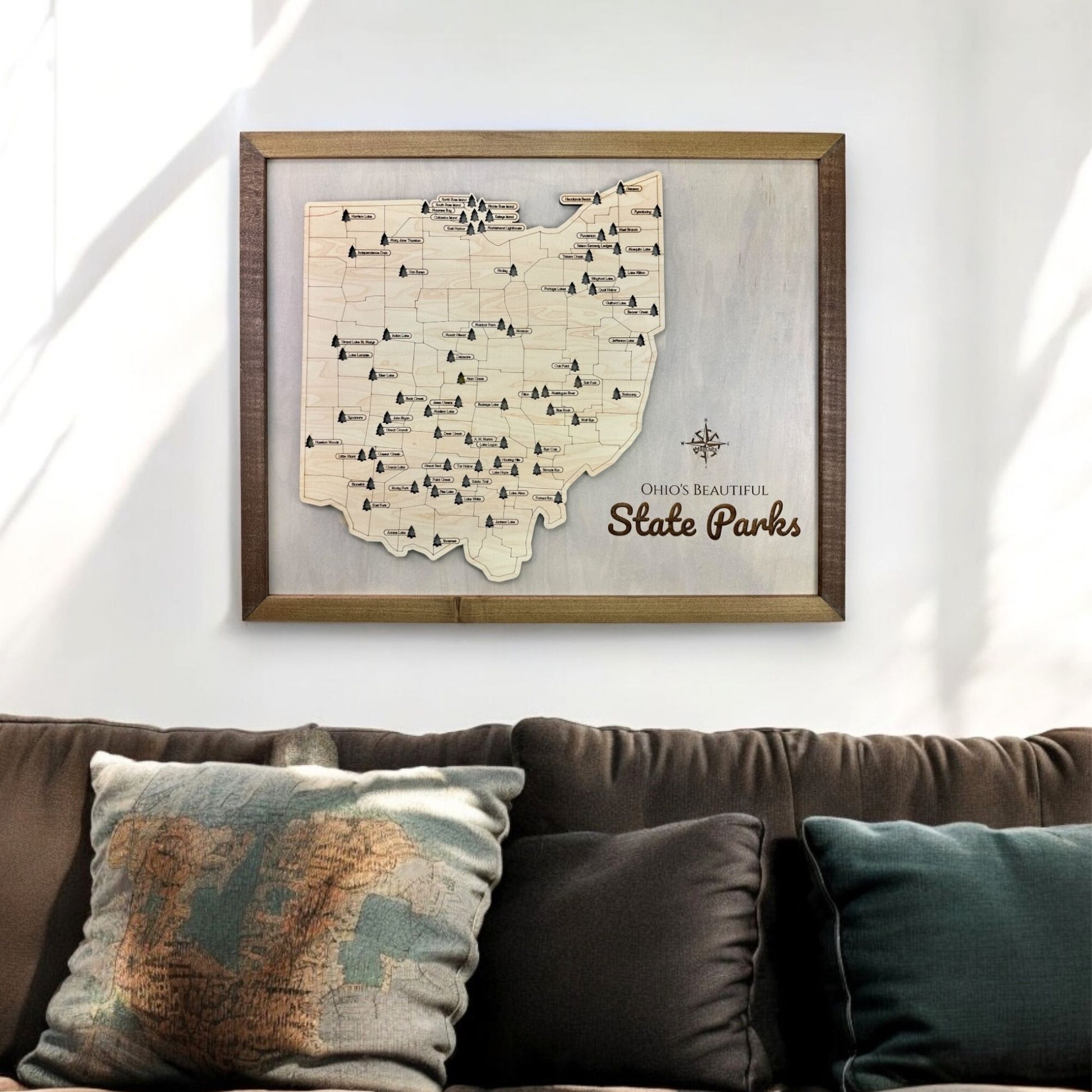 Wooden Ohio state park travel map hanging on wall above couch. 