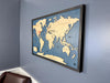 Wooden world travel map hangin on wall.