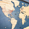 Close up sideview of red pins marking travel locations on a world travel map. 