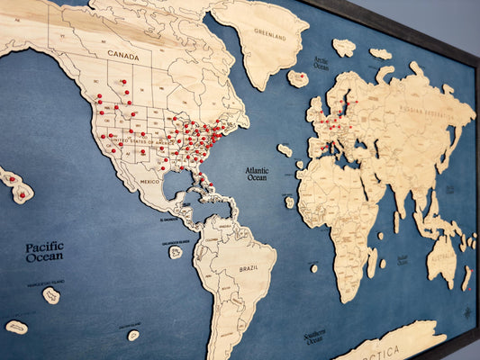 Up close look at red pins pushed into the world travel map. 