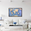 Wooden world topographic map framed on a wall above a white sofa in a living room.