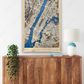 Large wooden Manhattan city map hanging on the wall above a dresser.